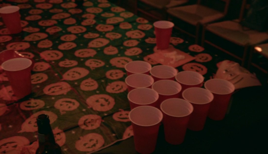 Red solo cups arranged on a Halloween-themed table, ready for a game of beer pong