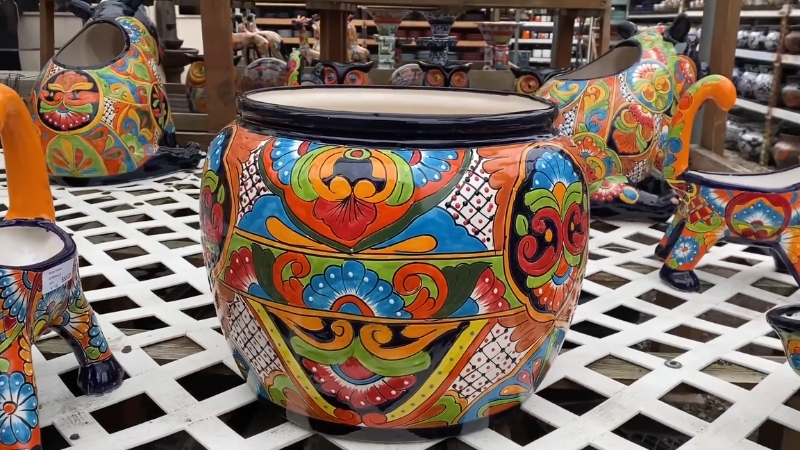 A Colorful Talavera Pottery Planter with Intricate Hand-Painted Designs Displayed Among Other Decorative Pieces