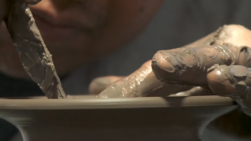 A Potter Shapes Wet Clay by Hand, Crafting a Piece of Talavera Pottery on A Spinning Wheel