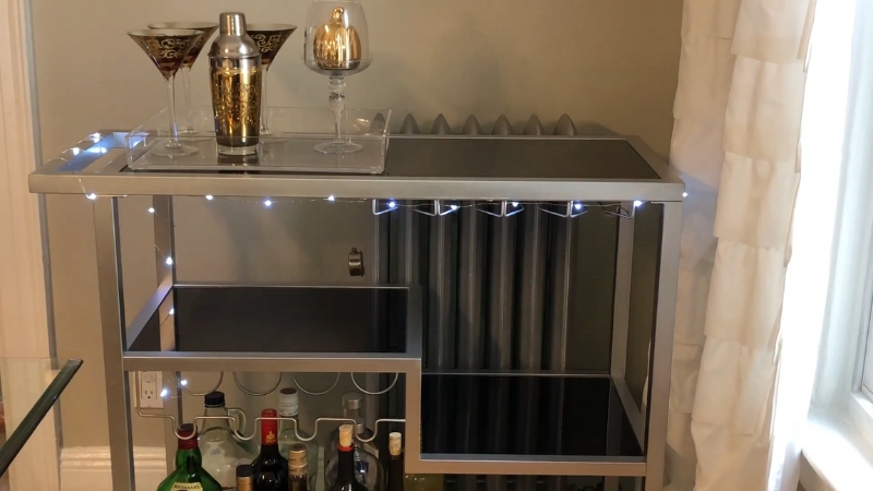 Modern DIY bar cart with black shelves, built-in wine rack, LED lights, and elegant glassware displayed on top